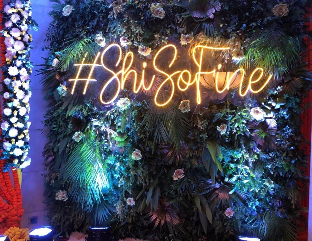 Neon sign on a floral wall